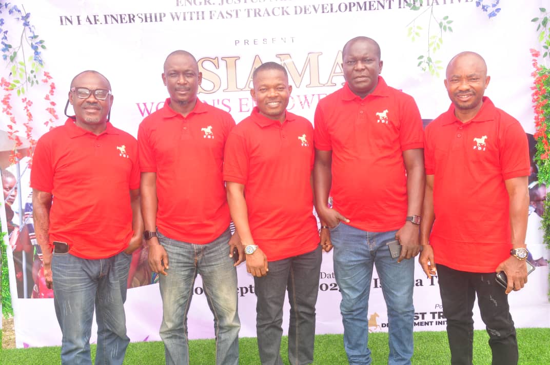 Fast Track Development Initiative team members in front of the Isiama Women’s Empowerment banner